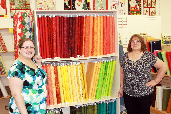 Photo of Katie Koll and Cindy Coll with fabric