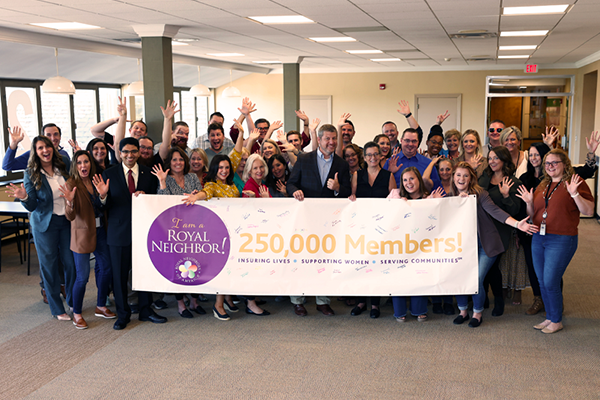 Photo of group of people holding 250K Member Milestone banner.