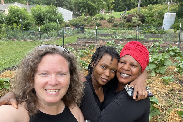 Photo of three happy women in garden outside.
