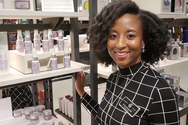 Photo of Kristy Alexander with beauty product display in store