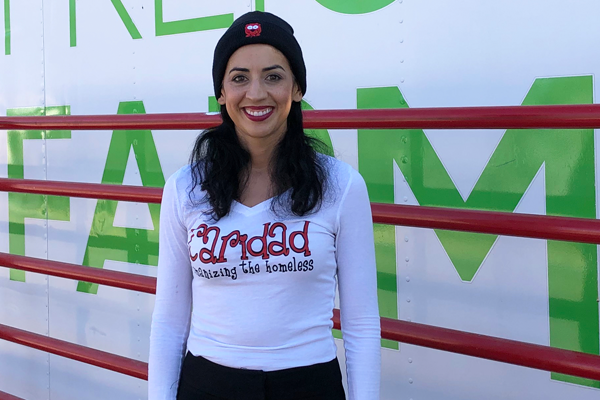 Photo of Merideth Spriggs in front of hydroponic shipping container