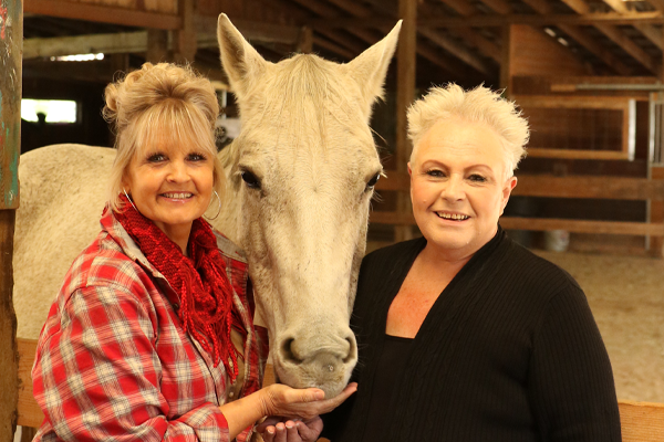 Photo of Robin Nelson and Kristine Eikenbary with white horse Photo of Robin Nelson and Kristine Eikenbary with white horse