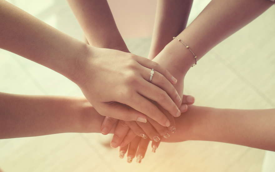 Diverse women's hands on top of each other for teamwork.
