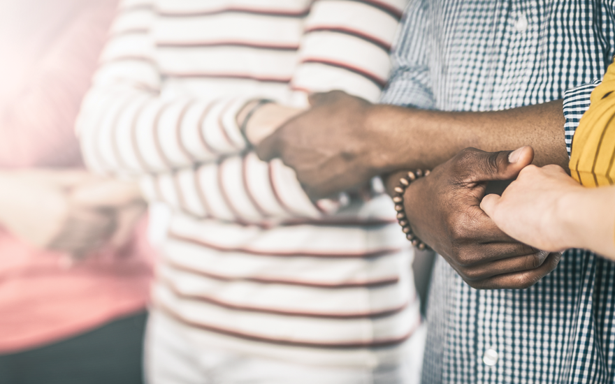 Friends holding hands to form a human chain