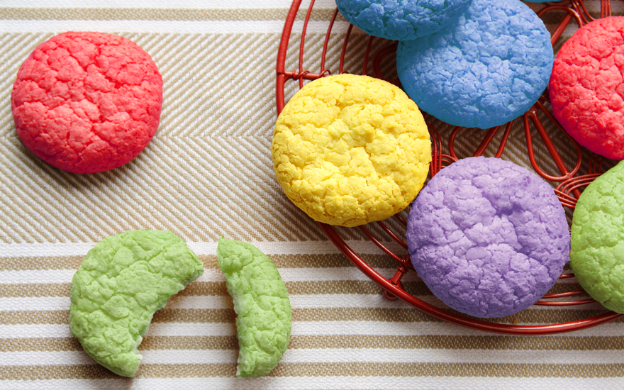 Colorful round cookies on a striped place mat.