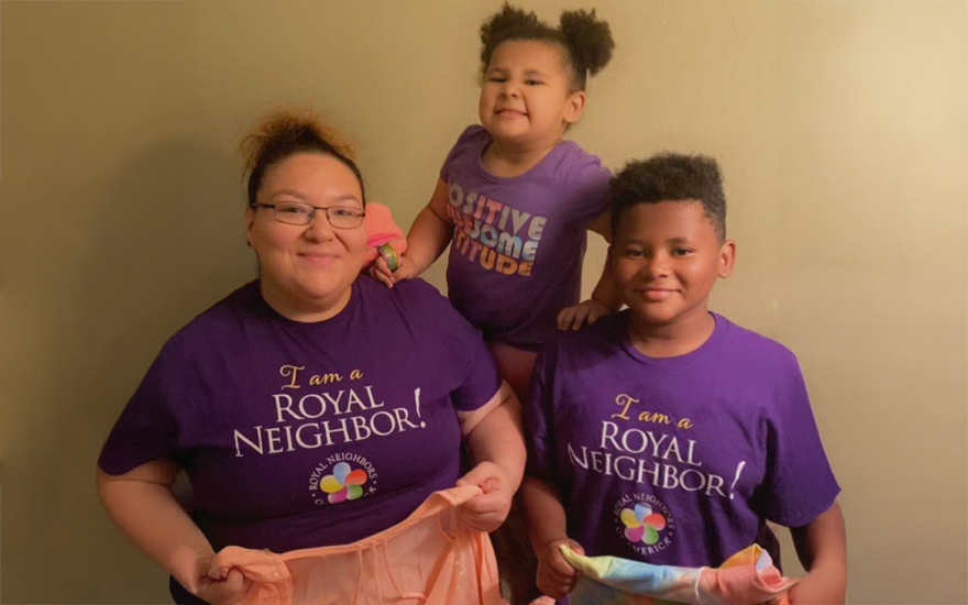 Mother with daughter and son holding clothing to donate.