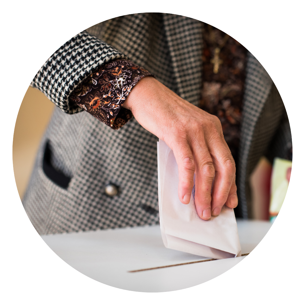 Close up of a woman's hand with putting a ballot in the box.