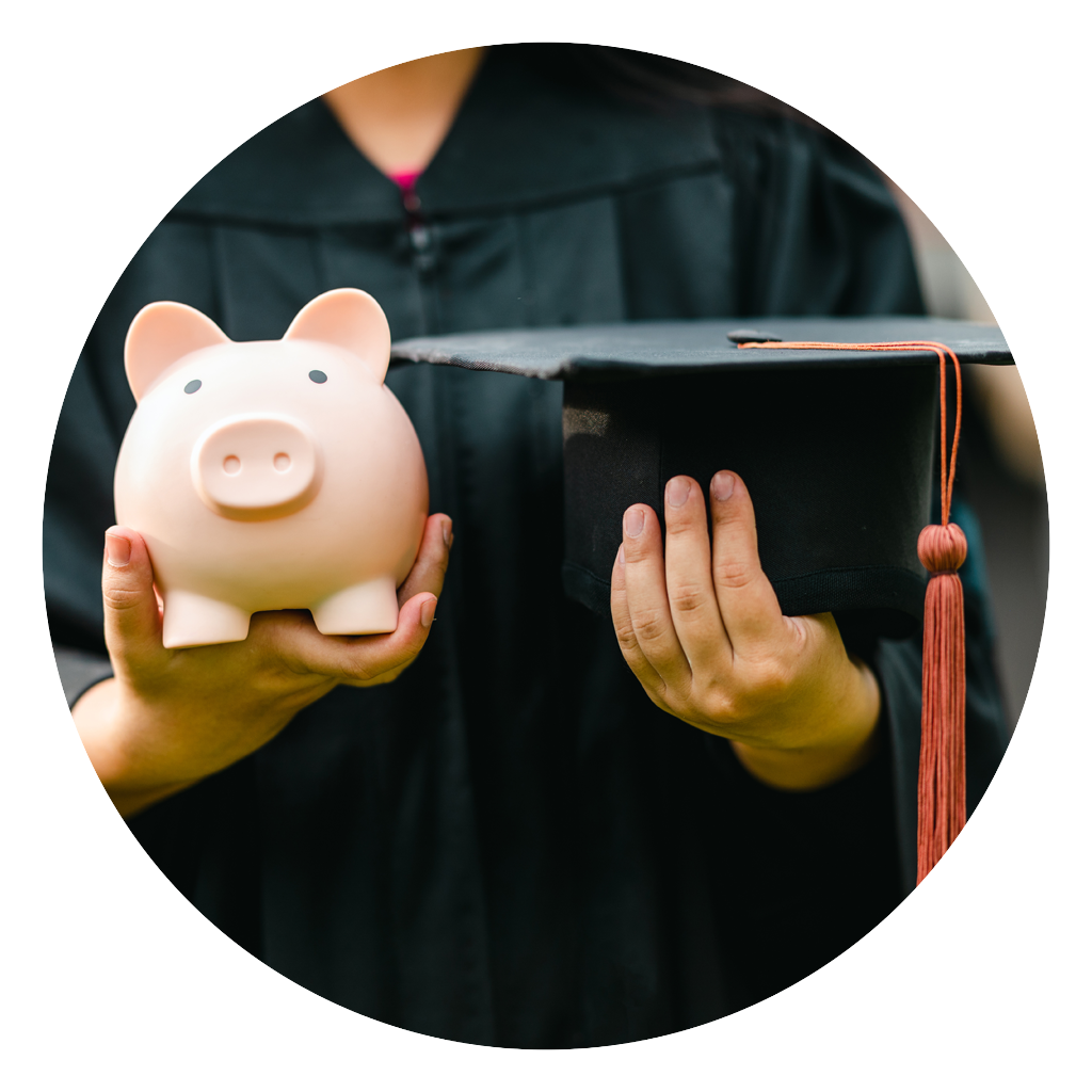 Close up of a graduate holding a piggy bank and graduation cap.